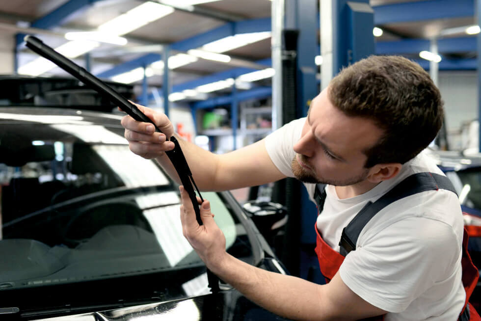 Tecnici GlassPartner SA durante il montaggio di un nuovo parabrezza Due tecnici specializzati lavorano in squadra per posizionare con precisione un nuovo parabrezza sul telaio di un'auto. L'immagine si concentra sull'attenzione ai dettagli e sulla competenza tecnica del team durante il processo di sostituzione certificato.